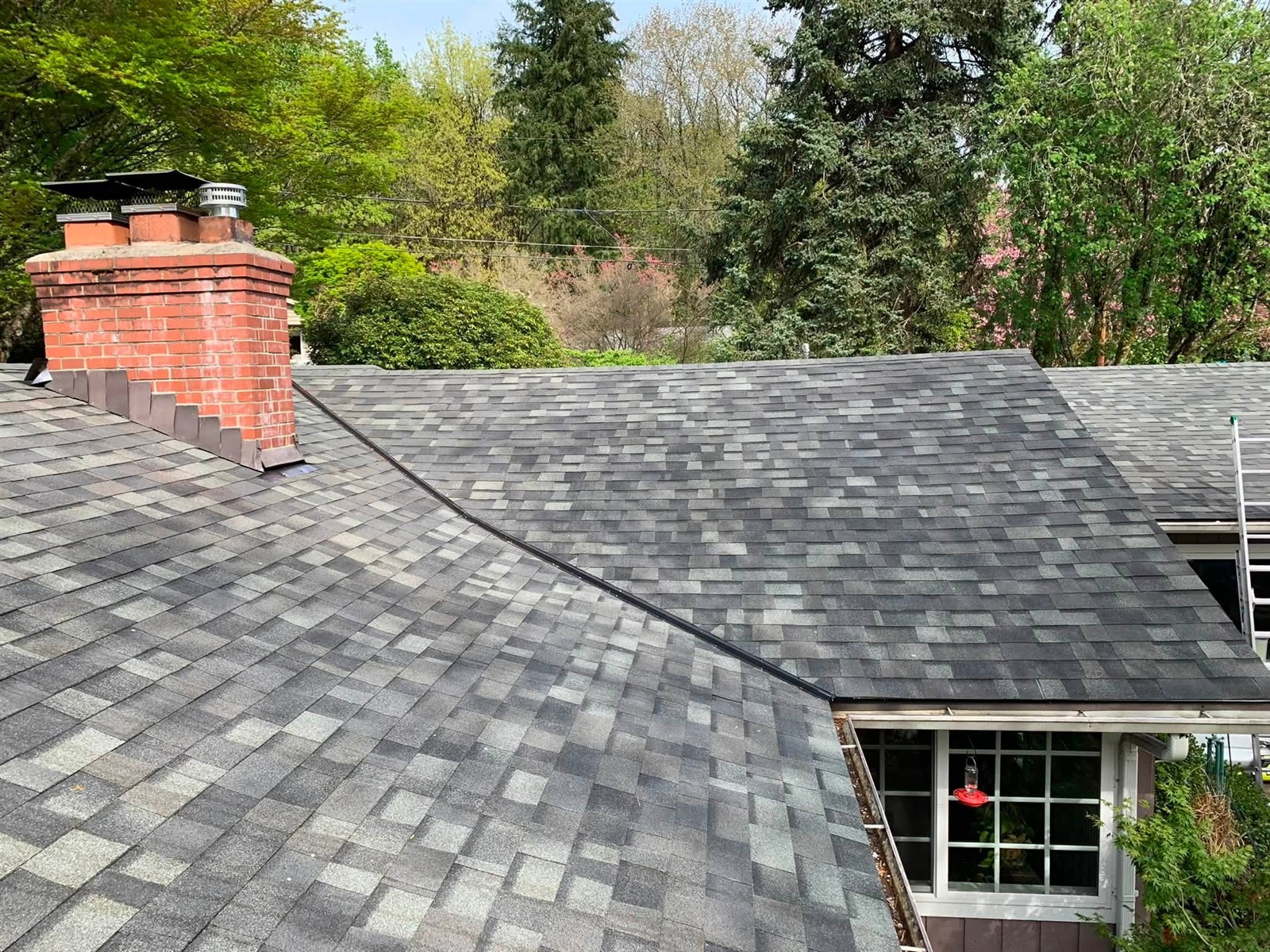 Gray shingle roof with a brick chimney